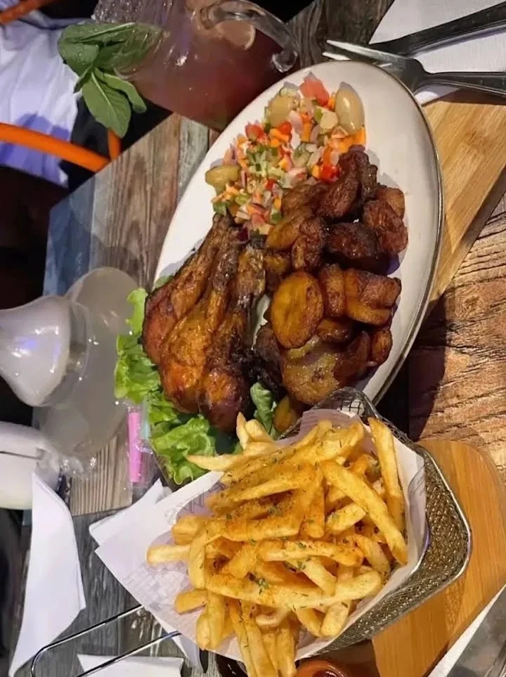 Grilled chicken with fried plantain, salad and fries