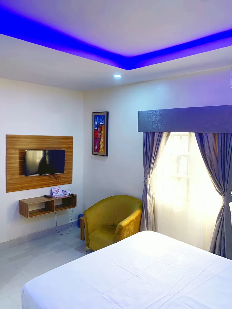 Hotel room with wall-mounted TV and armchair
