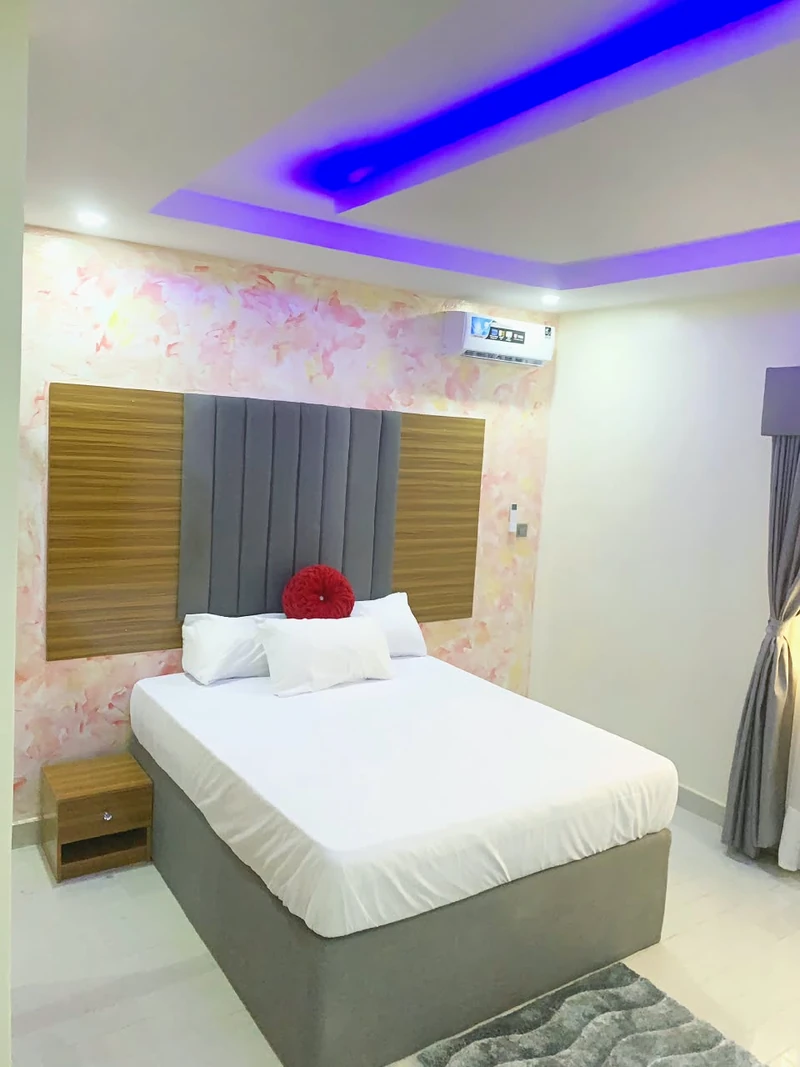 Hotel room with upholstered headboard and floral wall