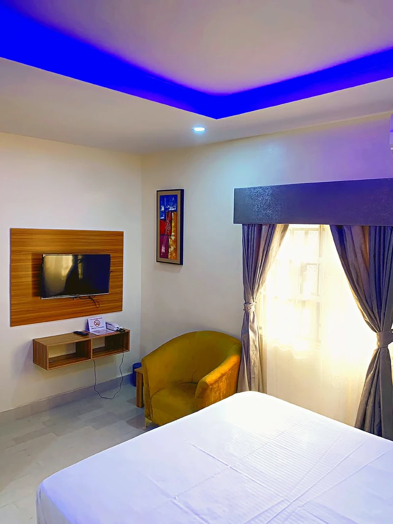 Hotel room with tub chair and wall TV